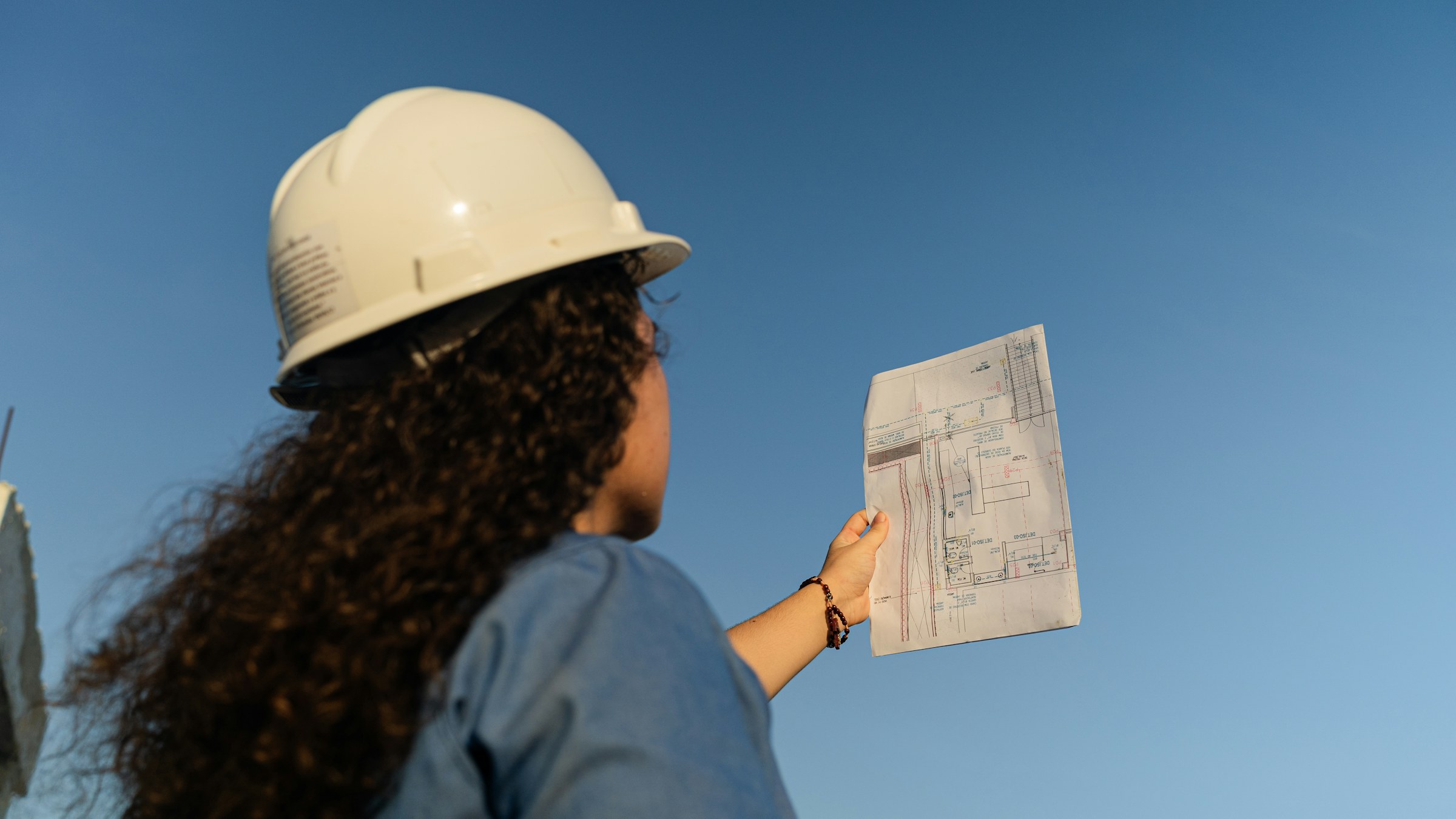 Engineer in a hard hat reviewing a site plan